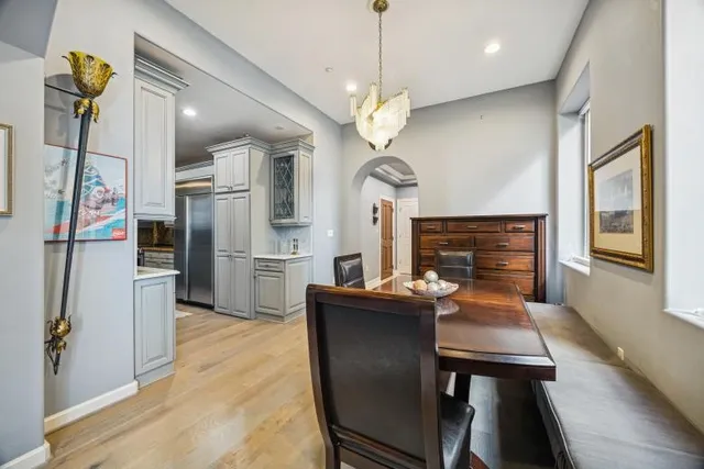 a view of a dining room with furniture a chandelier and wooden floor