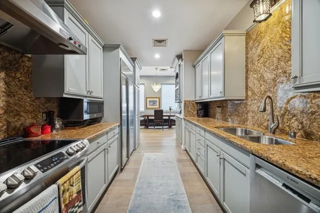 a large kitchen with stainless steel appliances granite countertop a lot of counter space
