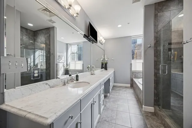 a large bathroom with a granite countertop sink a mirror and a shower