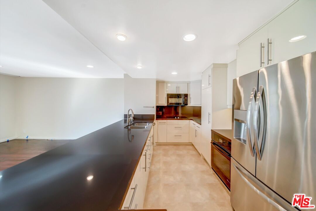 2160 Century Park, Unit 1503 Los Angeles, CA 90067 - Photo 12 of 22 a large white kitchen with stainless steel appliances