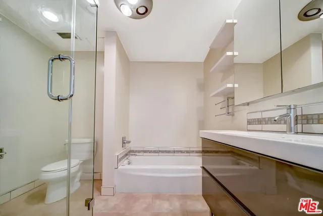 a bathroom with a granite countertop sink a toilet and shower