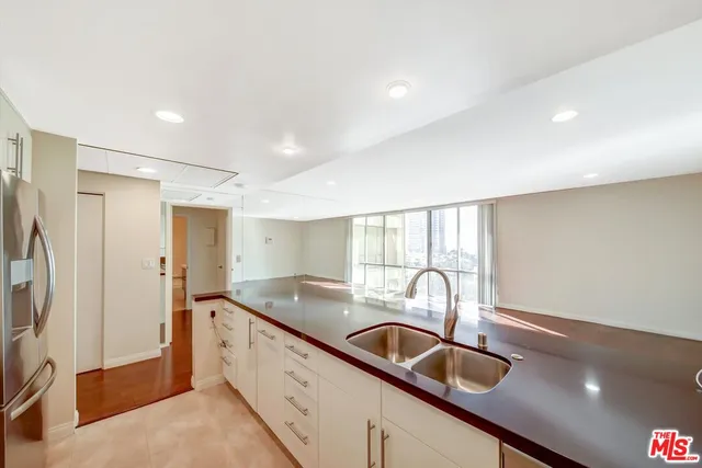 a kitchen with granite countertop a sink and a refrigerator
