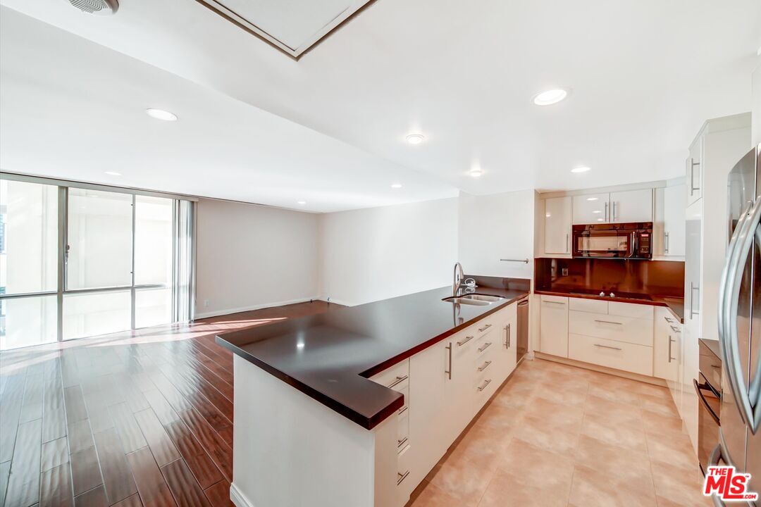 2160 Century Park, Unit 1503 Los Angeles, CA 90067 - Photo 10 of 22 a kitchen with stainless steel appliances granite countertop a sink counter space and wooden floor