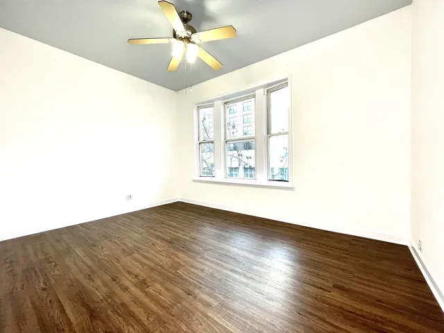 a view of an empty room window and wooden floor