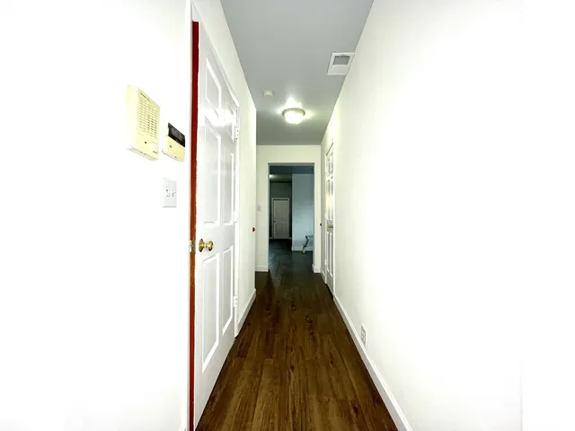 a view of a hallway with wooden floor