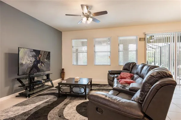 a living room with furniture ceiling fan and a window