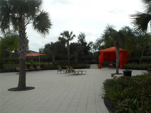a view of swimming pool with table and chairs under an umbrella