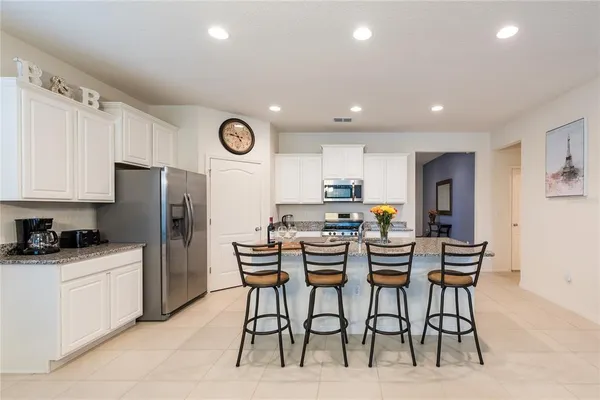 a kitchen with stainless steel appliances kitchen island granite countertop a table and chairs in it