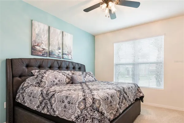 a bedroom with a large bed and a chandelier
