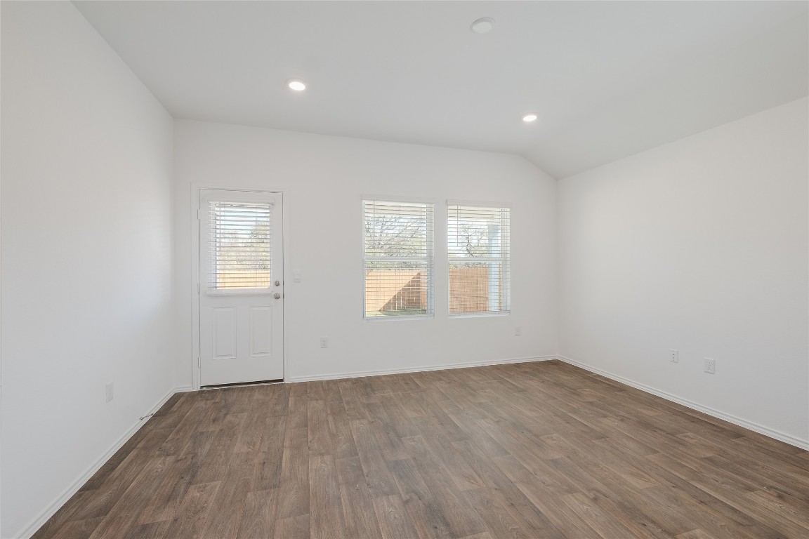 12202 Pike Bend Mustang Ridge, TX 78610 - Photo 11 of 24 an empty room with wooden floor and windows