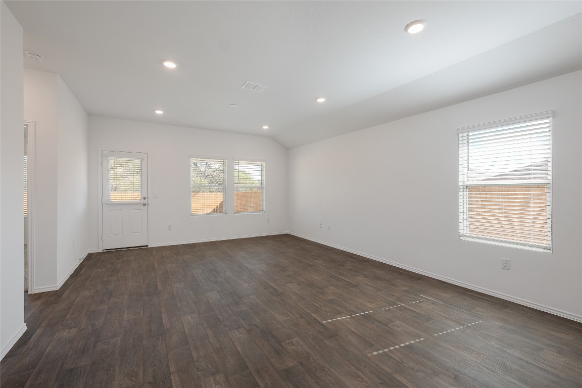 12202 Pike Bend Mustang Ridge, TX 78610 - Photo 9 of 24 an empty room with wooden floor and windows