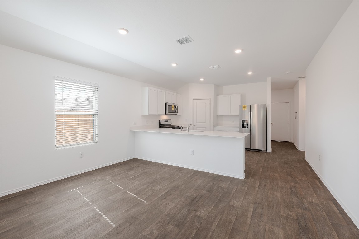 12202 Pike Bend Mustang Ridge, TX 78610 - Photo 10 of 24 a view of an empty room with kitchen and window