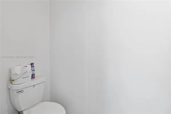 a white toilet sitting next to a white sink and vanity