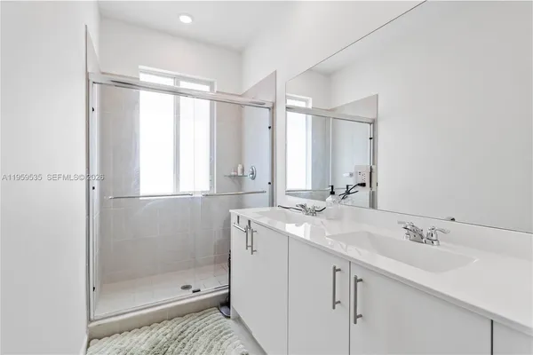 a bathroom with a shower sink and mirror