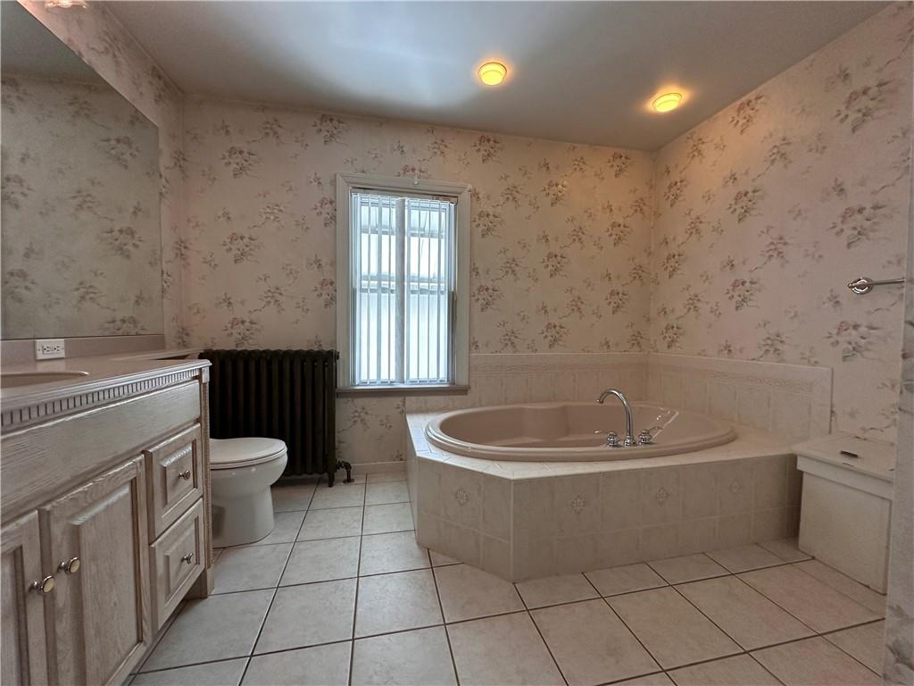 26 South Main Street Houston, PA 15342 - Photo 32 of 44 a bathroom with a bathtub a sink a toilet a window and vanity