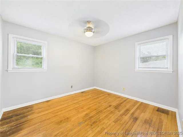 a view of empty room with wooden floor