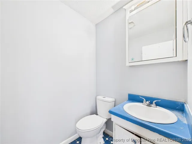 a bathroom with a toilet a sink and mirror