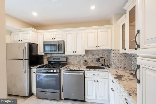 a kitchen with white cabinets and white appliances