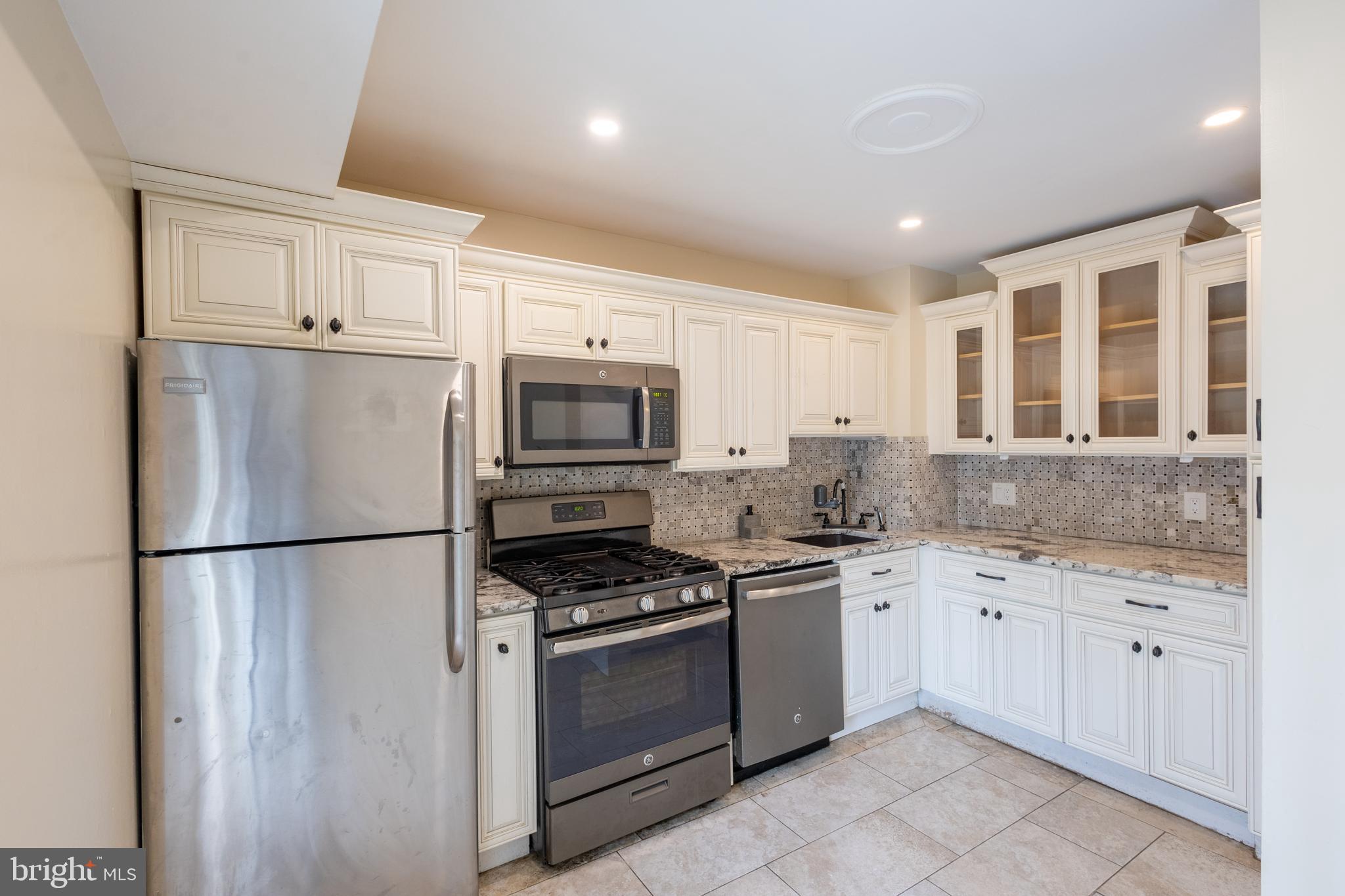 3332 Claridge Court Silver Spring, MD 20902 - Photo 21 of 30 a kitchen with granite countertop a sink stainless steel appliances and cabinets