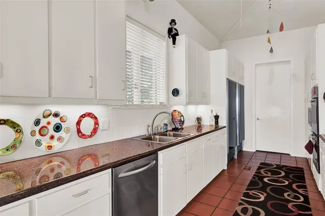 a kitchen with stainless steel appliances a sink a stove a chimney and cabinets
