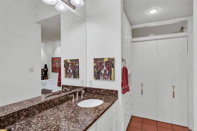 a bathroom with a granite countertop sink a mirror and shower