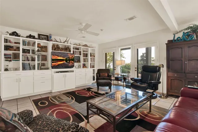 a living room with furniture a flat screen tv and a floor to ceiling window