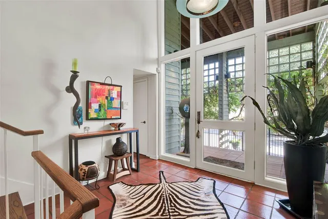 a living room with furniture a flat screen tv and a floor to ceiling window