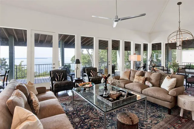 a living room with furniture a large window and a chandelier