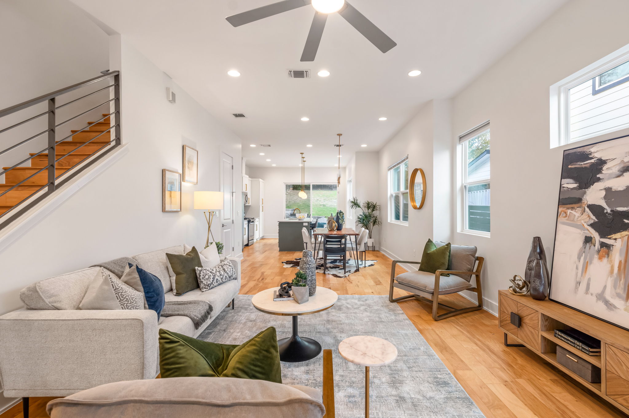 a living room with furniture kitchen view and a window