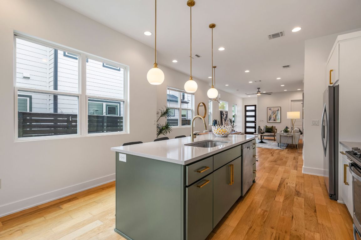 1301 Cometa Street, Unit A Austin, TX 78721 - Photo 10 of 38 Light-filled workspace featuring a large island, generous counter space, and oversized windows that enhance the airy, open feel