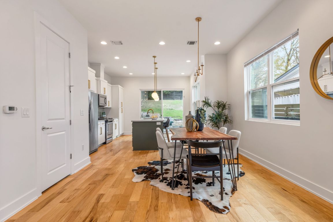 1301 Cometa Street, Unit A Austin, TX 78721 - Photo 12 of 38 Seamless flow from the dining area to the kitchen, highlighting the open-concept design and inviting atmosphere