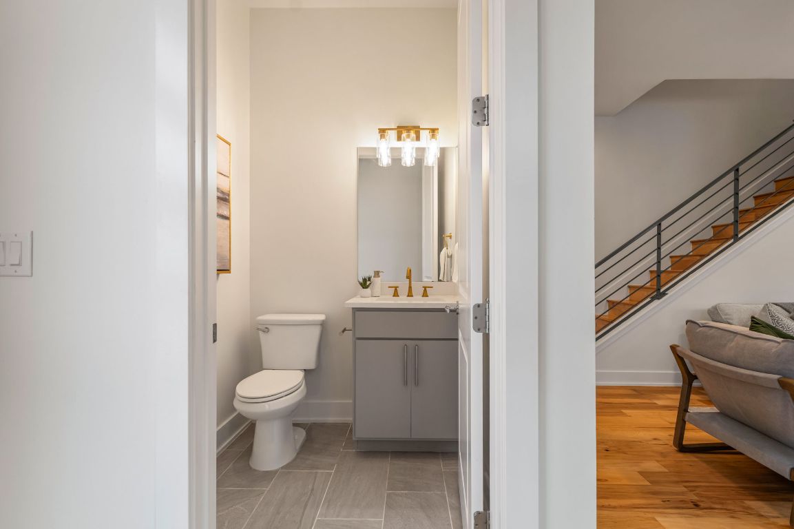 1301 Cometa Street, Unit A Austin, TX 78721 - Photo 14 of 38 Main-level powder room with a modern vanity, gold fixtures, and updated lighting