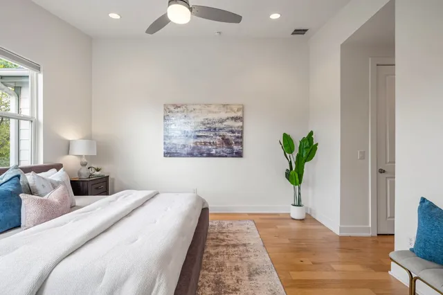a large bed sitting in a bedroom next to a window with a chandelier