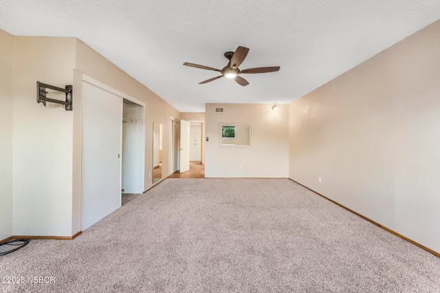 a view of a livingroom with a ceiling fan and window
