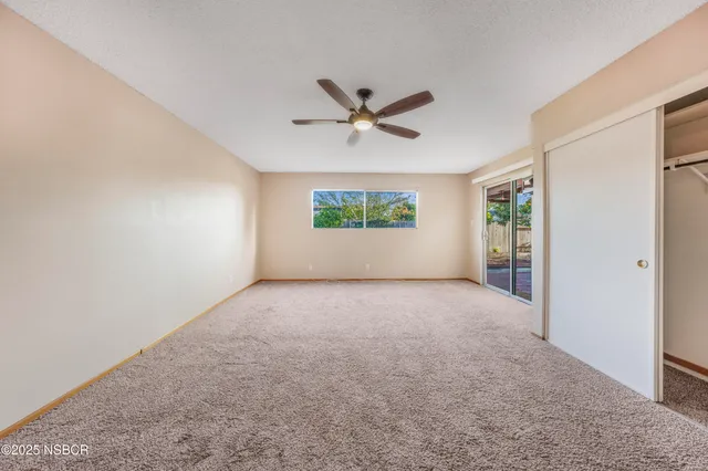 an empty room with a window and a fan