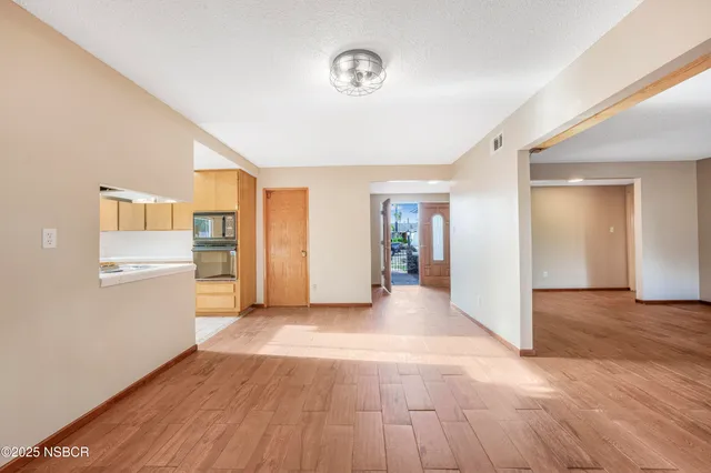 a view of a kitchen with wooden floor and windows
