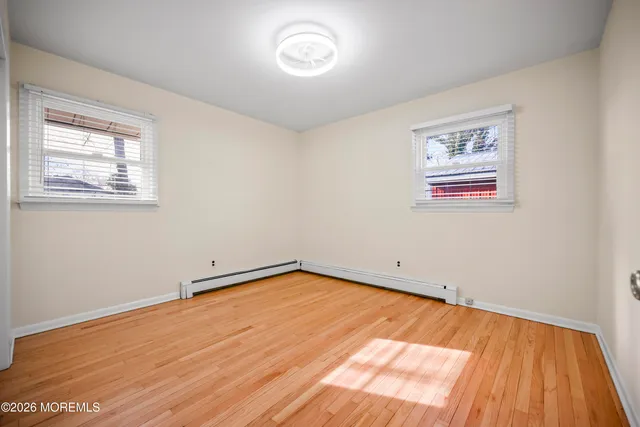 a view of a room with wooden floor and a window