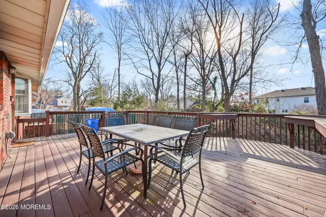 a view of a roof deck with table and chairs and wooden floor