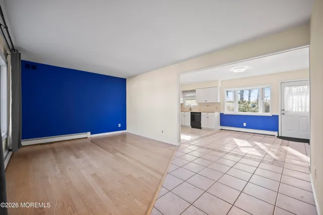 a view of empty room with wooden floor and windows