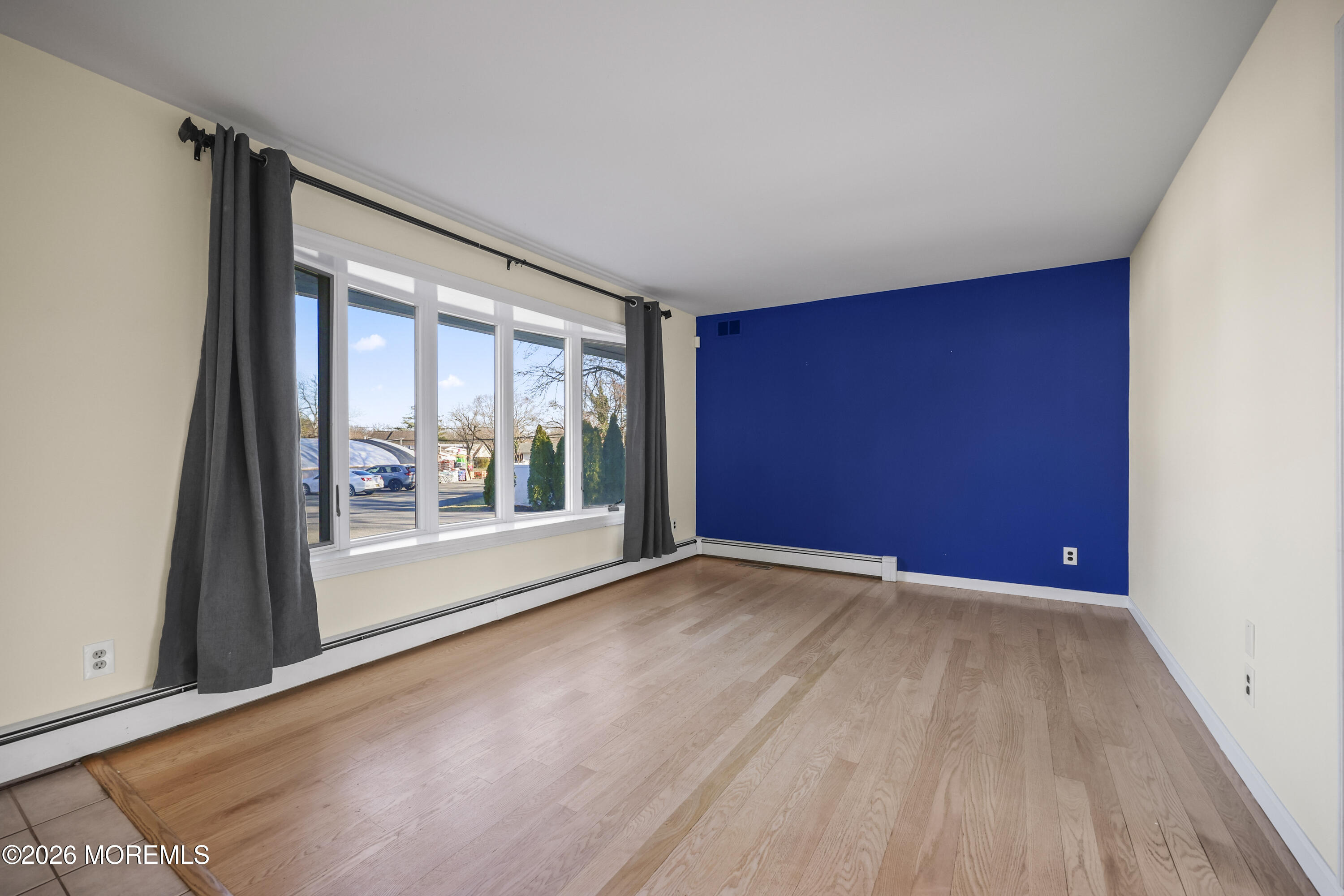 573 Lloyd Road Aberdeen, NJ 07747 - Photo 5 of 23 a view of empty room with wooden floor and fan