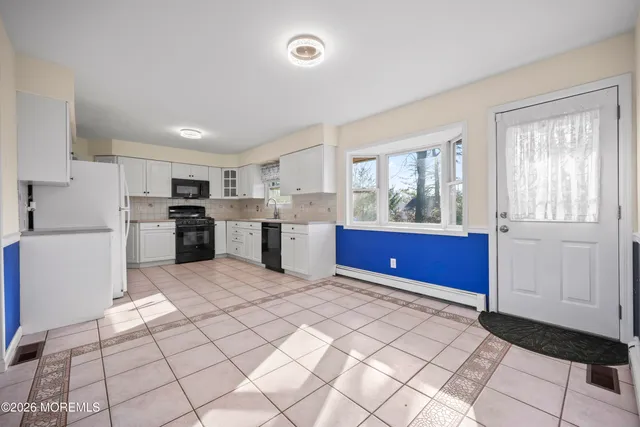 a kitchen with stainless steel appliances kitchen island granite countertop a refrigerator and a stove top oven