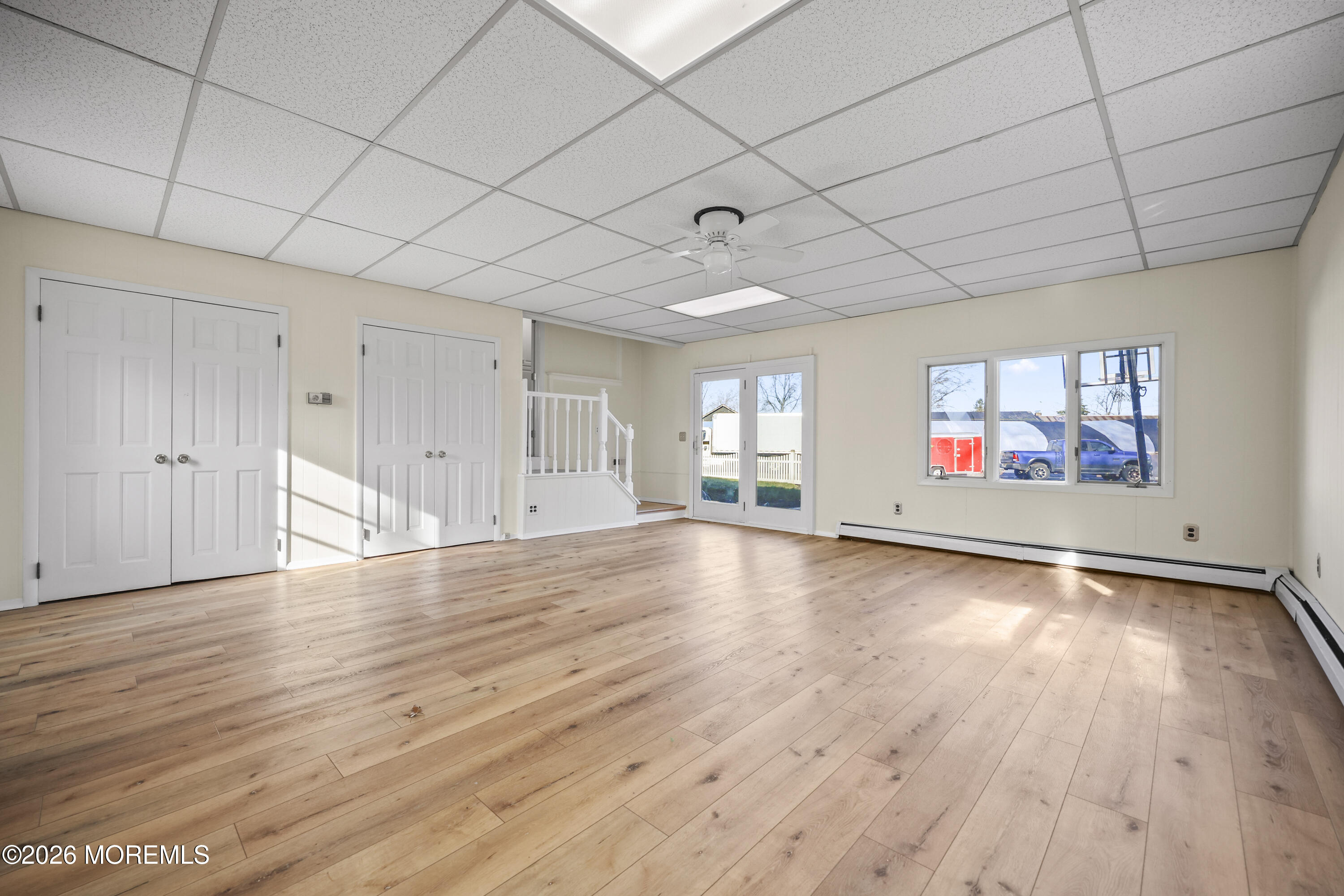 573 Lloyd Road Aberdeen, NJ 07747 - Photo 9 of 23 an empty room with wooden floor and windows