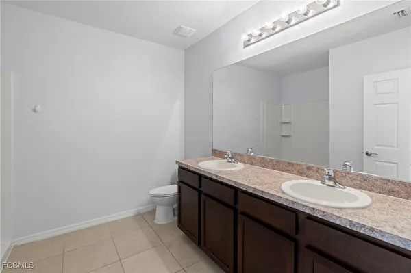 a bathroom with a granite countertop sink a toilet and a mirror