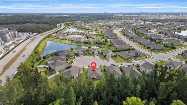 an aerial view of residential houses with outdoor space and trees