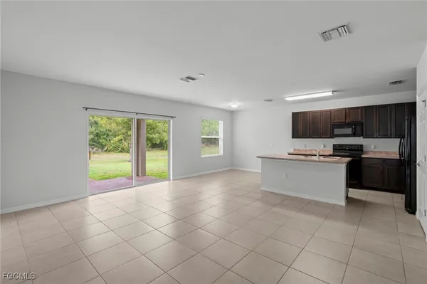 a view of kitchen with granite countertop a stove top oven a sink and a window