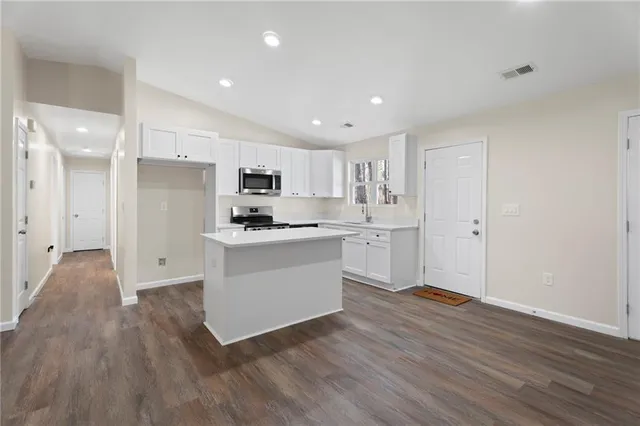 a kitchen with white cabinets and stainless steel appliances
