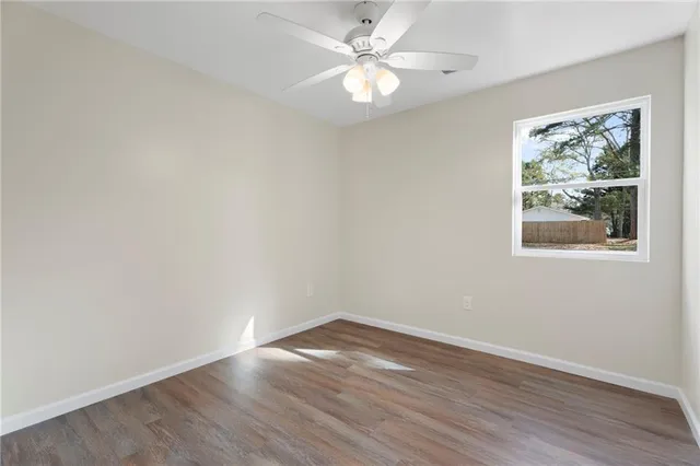 an empty room with wooden floor and window
