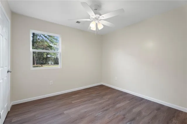 a view of a big room with wooden floor and windows