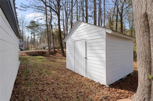 a backyard of a house with barbeque oven and trees