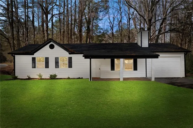 a view of a house with backyard and trees